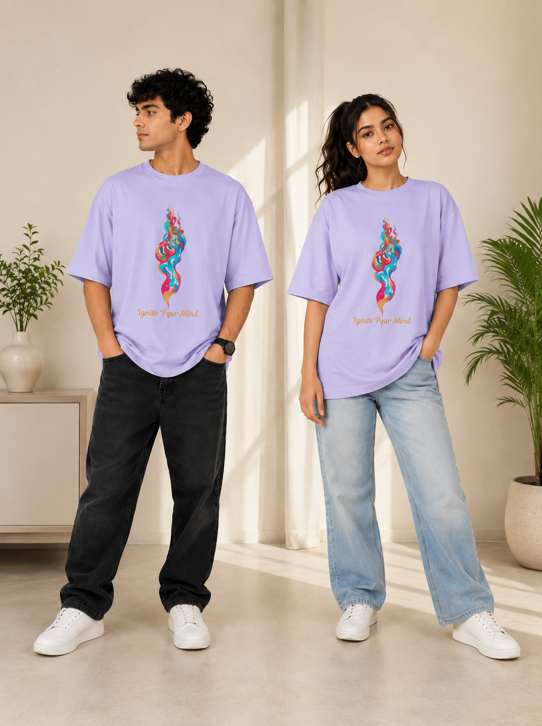 A man and a woman modeling matching oversized light purple t-shirts with a colorful snake graphic and the words 'Spice Your Soul' printed on the front, styled with black and light-wash jeans and white sneakers in a bright indoor setting.