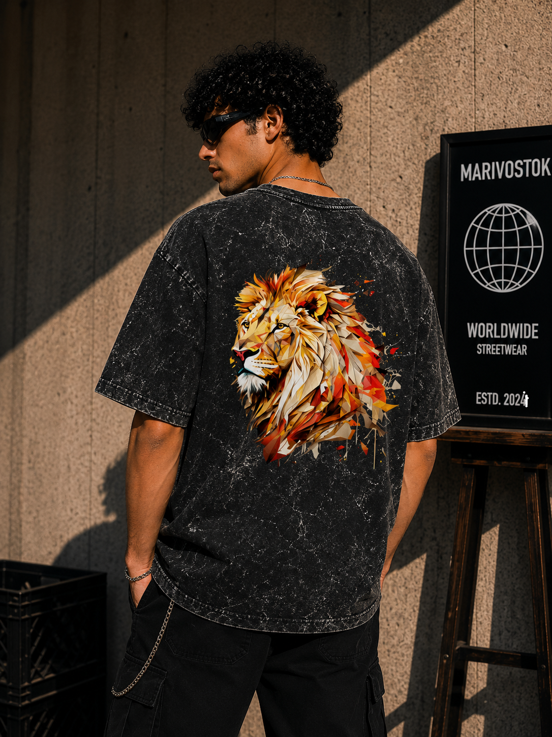 Person wearing a black t-shirt with a colorful lion design on the back, standing against a textured wall.