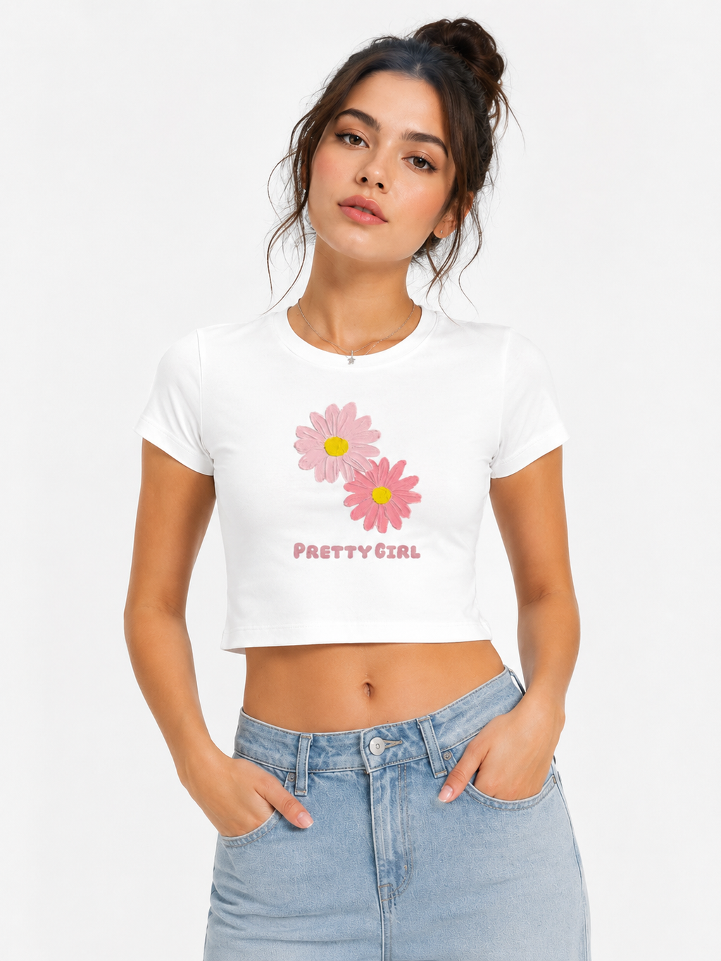 Woman wearing a white t-crop top with pink floral design and 'Pretty Girl' text, standing against a plain background.